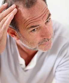 photo of a man holding his head